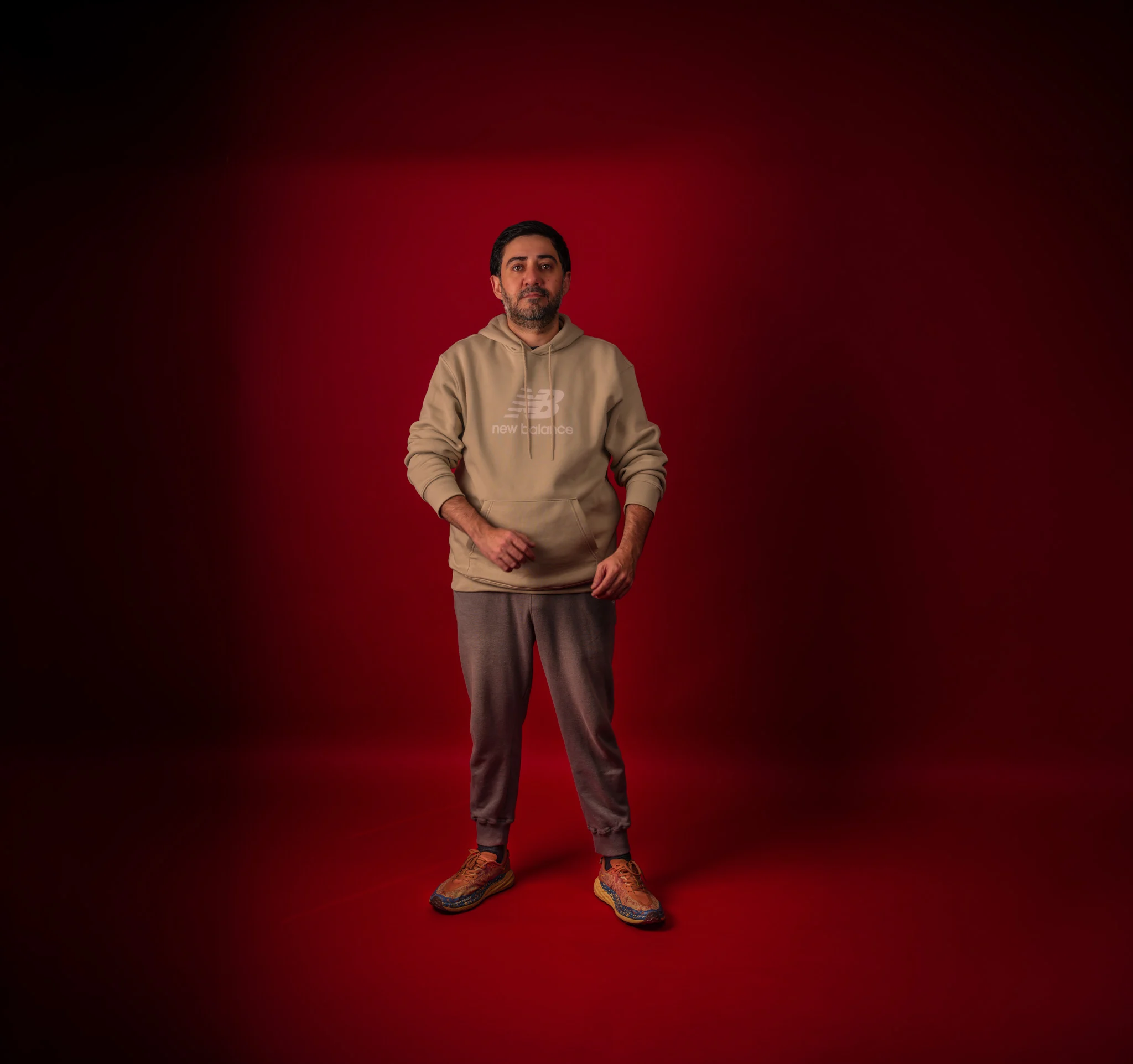 Bahlul Mikayilov standing against a deep red studio backdrop